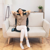Memory foam massage seat cushion on a sofa, featuring vibration modes and heating for targeted muscle relaxation.