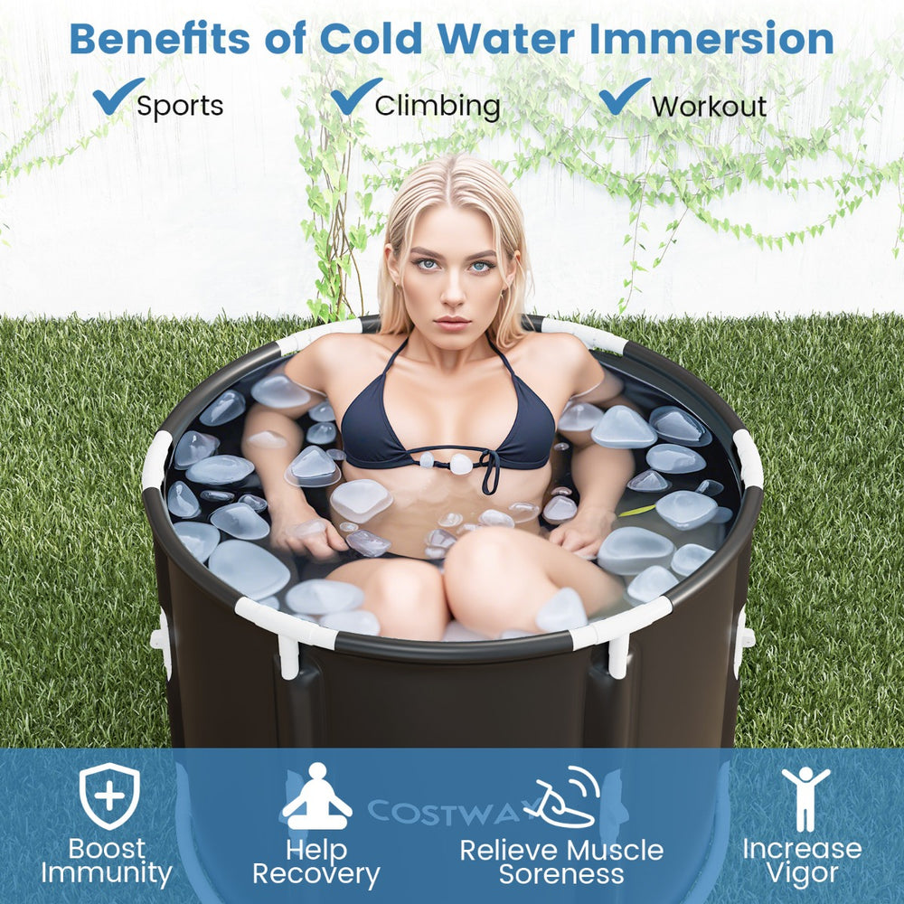 A woman sitting in a Costway foldable ice bath tub with ice cubes for cold water immersion.